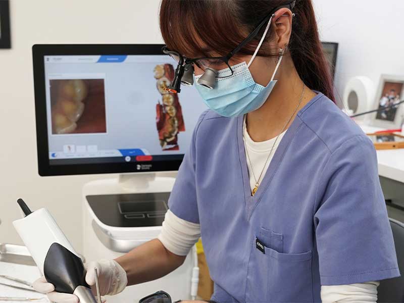 dentist working on a patient with hi res screen showing internal works