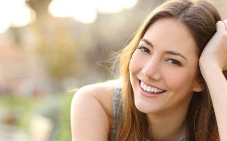 Young-woman-in-park-smiling-with-straight-white-healthy-teeth-e1461884009947